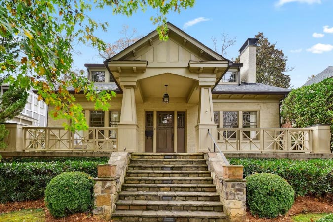 A gorgeous Craftsman style home in Atlanta’s Brookwood Hills neighborhood. The home features stone steps leading up to a gabled entryway in the center of a large front porch.