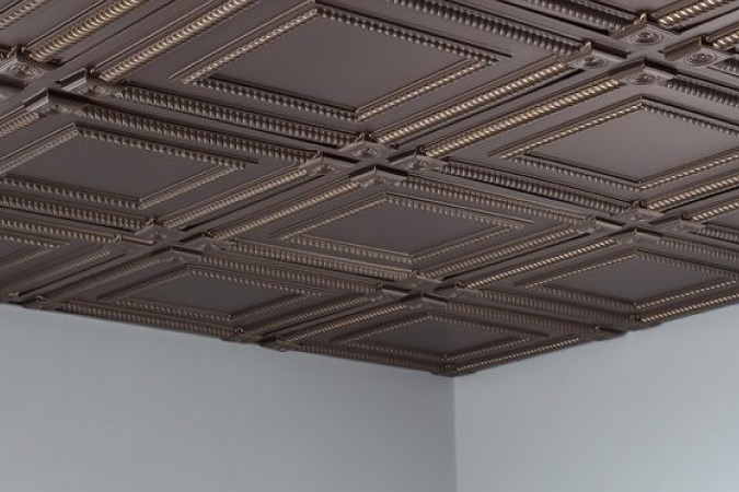 Close up of an ornate drop ceiling with a faux tin look.