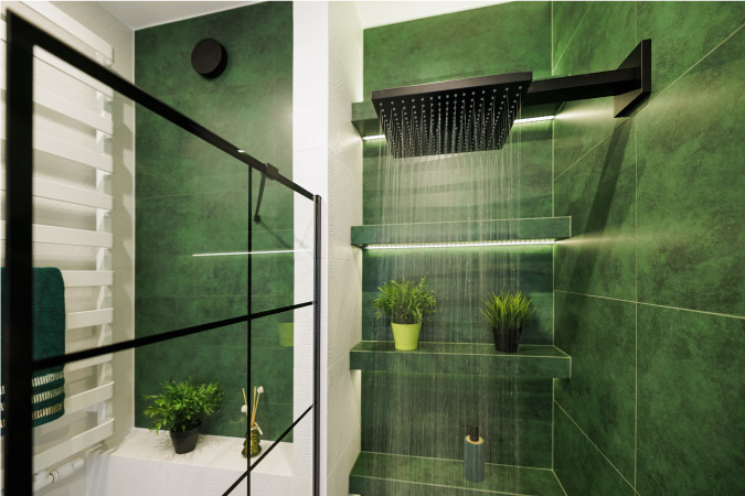 View from inside a green tiled shower as the shower head is running