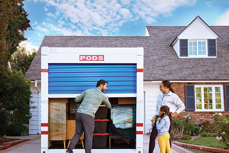 A family of three closes the door to the PODS container as the get ready for their move to Memphis.