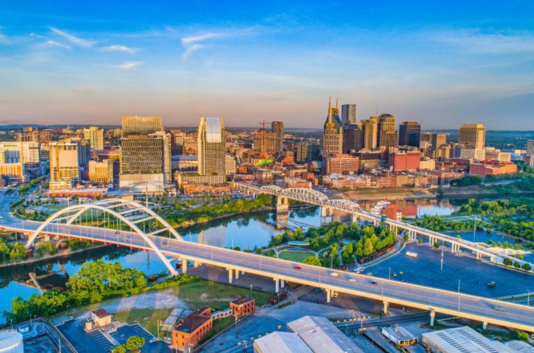 Aerial view of Nashville, Tennessee, featuring the city skyline, river, and bridges