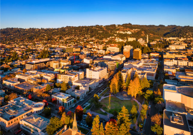 Aerial view of Berkeley, California, during the golden hour, with the Berkeley Hills in the distance.