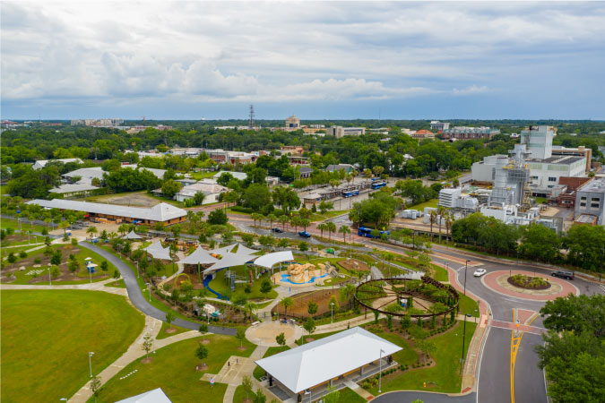 Aerial view of a city park in Gainesville, Florida, with the surrounding lush greenery and clean city streets.