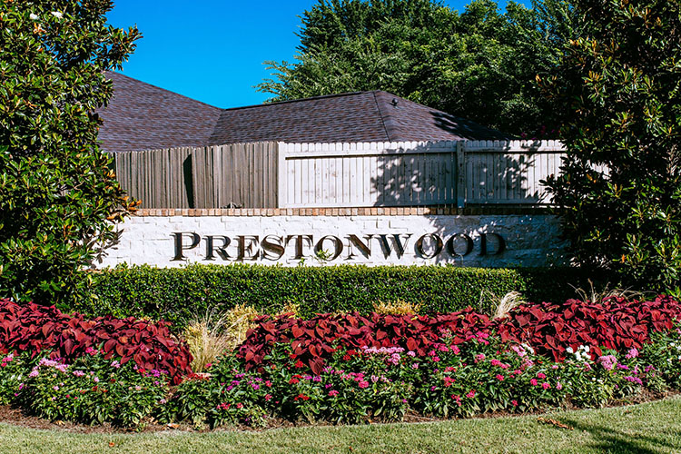 The Prestonwood, Dallas entrance sign. Bushes, shrubs, and flower beds frame the sign