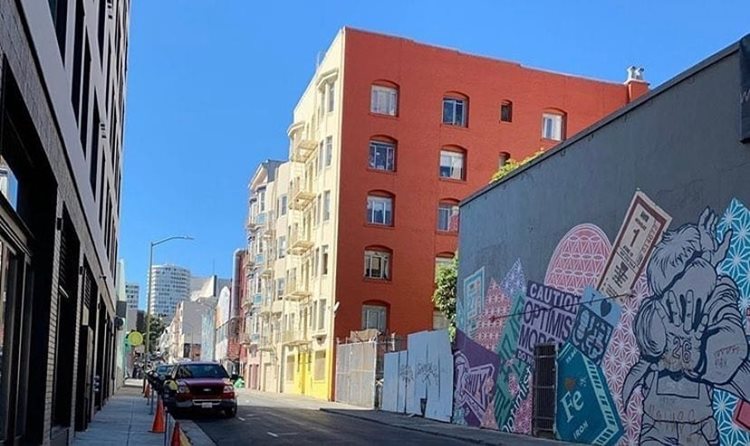 Large residential and commercial buildings line a street in The Tenderloin neighborhood of San Francisco — one of the more budget-friendly San Francisco neighborhoods.