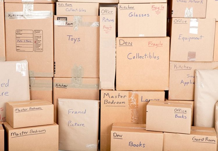 Stacks of moving boxes labeled with rooms and contents