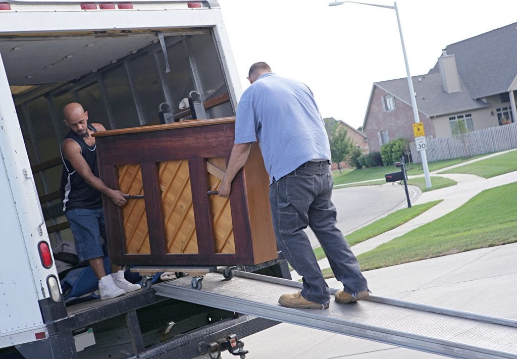 men moving a piano onto a moving truck