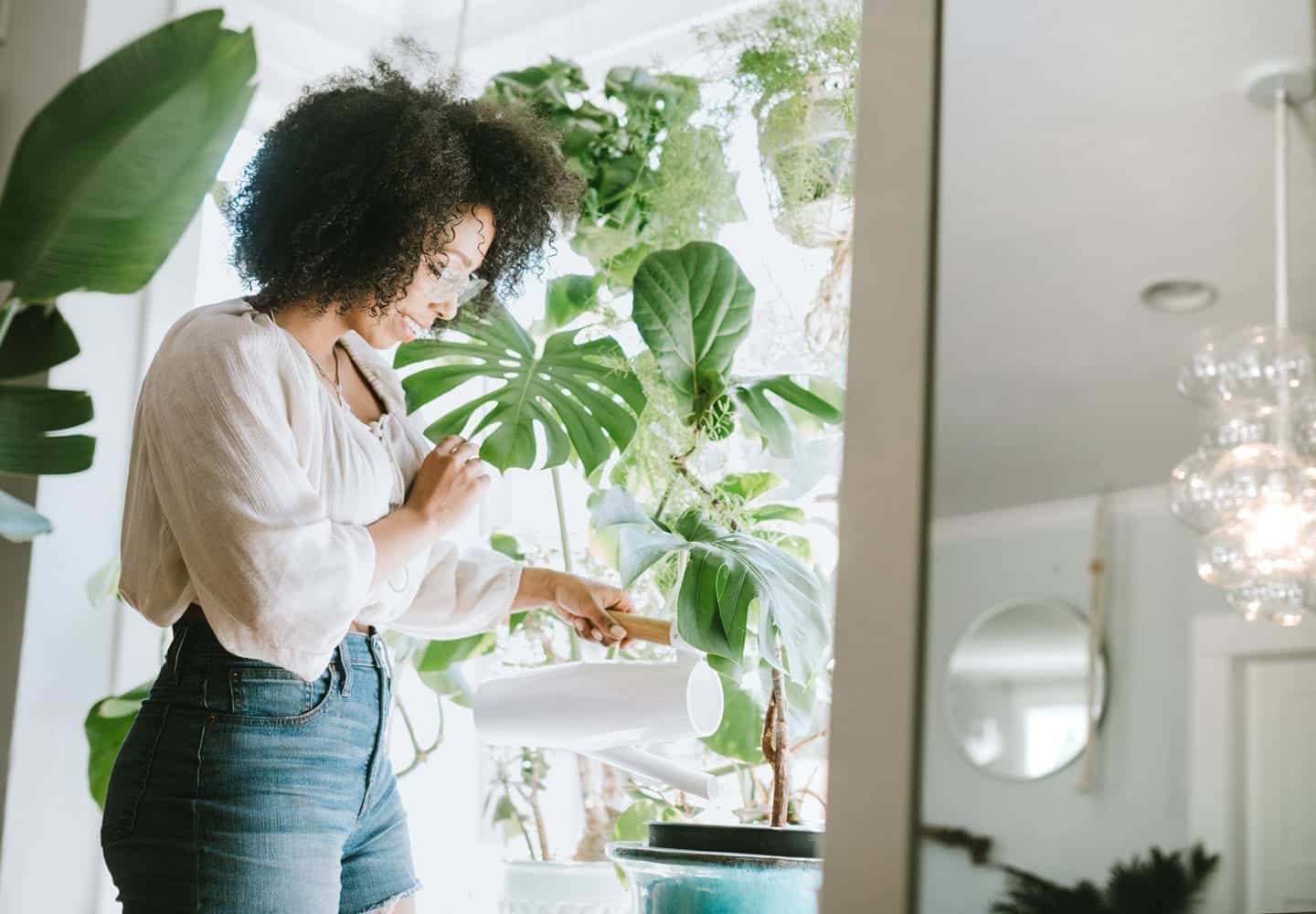 woman watering plants in her home