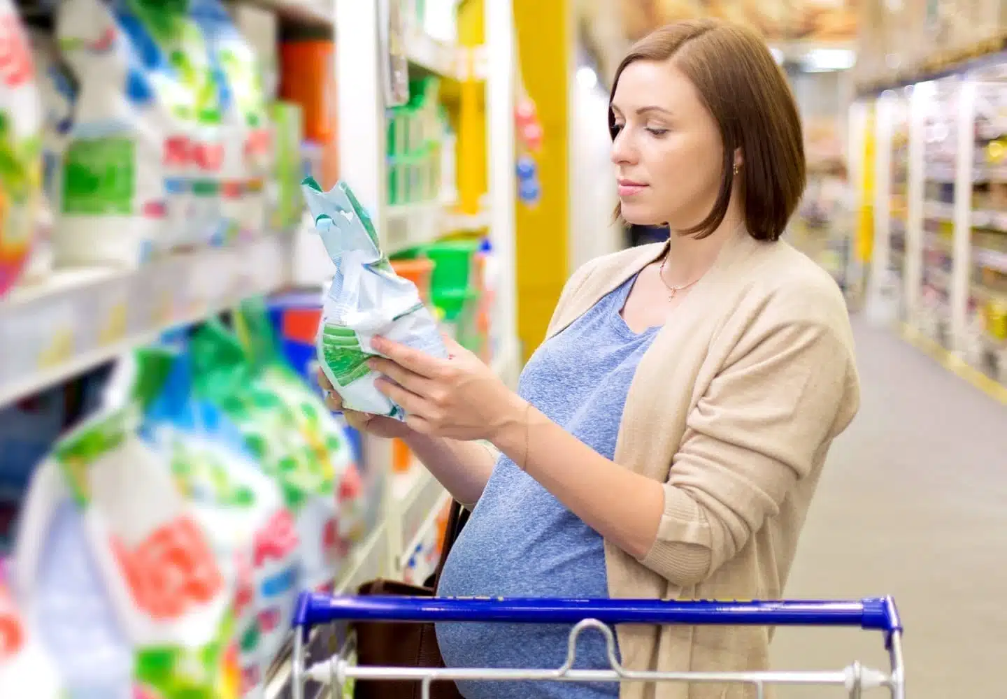 A pregnant woman inspects cleaning supplies