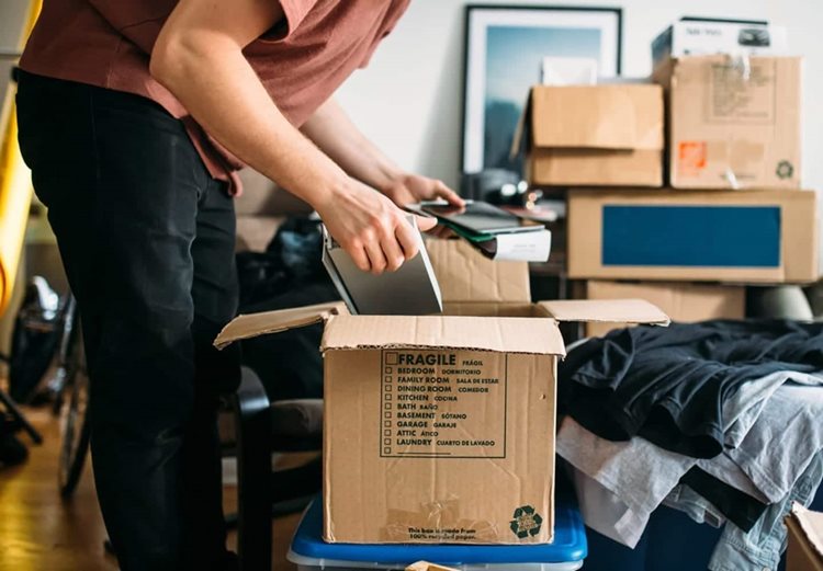 A man sorts through clutter in a cardboard box