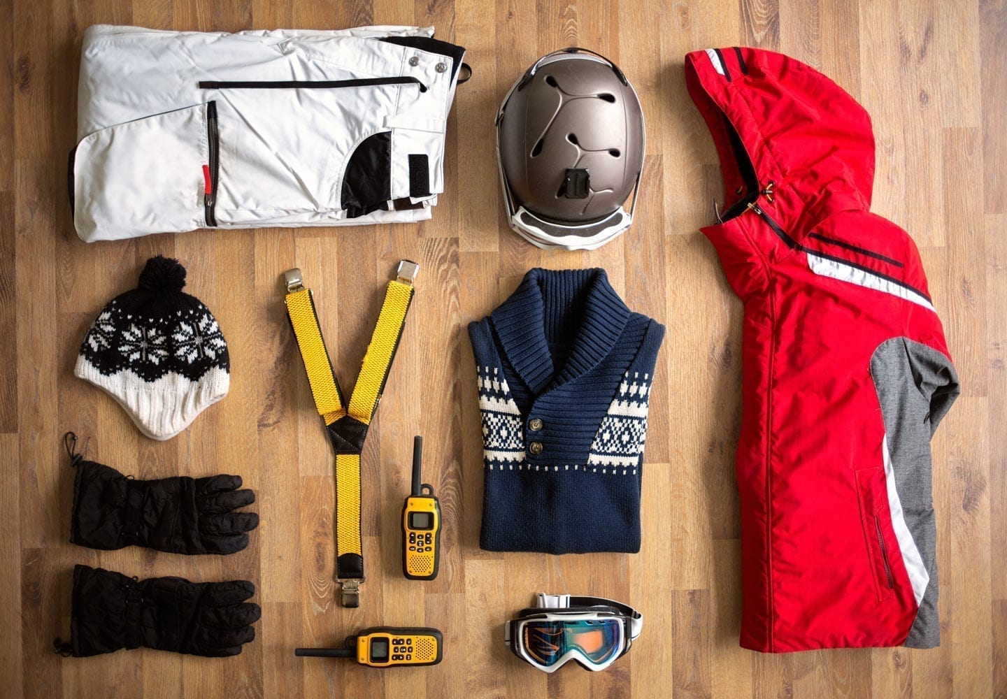 Ski gear spread out on a hardwood floor