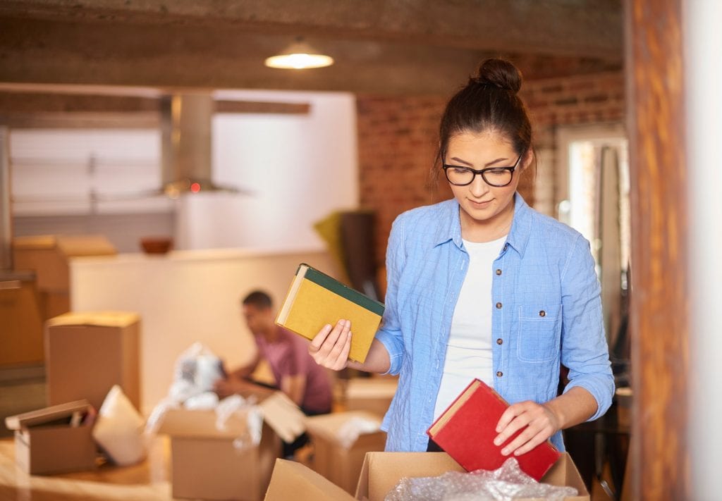 girl packing books before placing them in climate-controlled storage