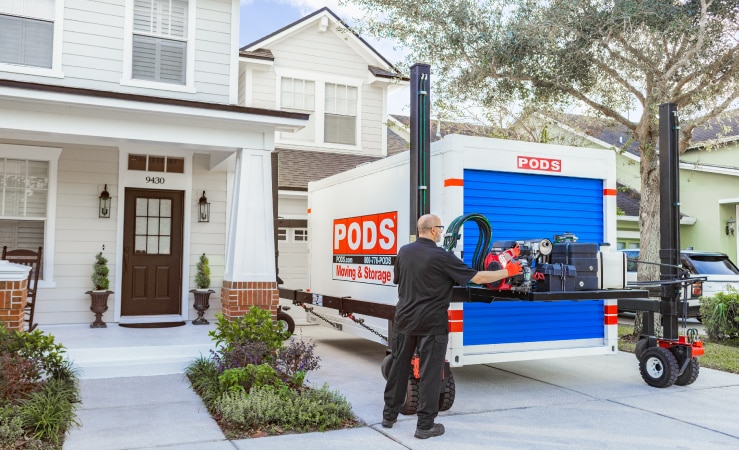 A PODS driver uses PODZILLA to maneuver a PODS moving container into a customer’s driveway.