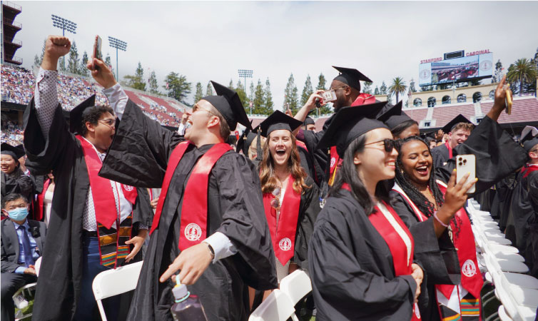 Students at Stanford University celebrate their graduation with enthusiasm in the school’s stadium.