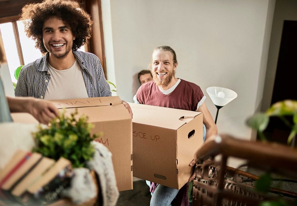 friends moving boxes and other items upstairs