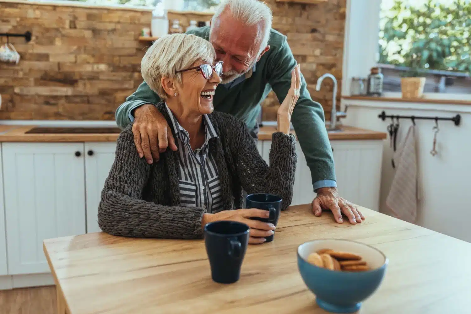 elderly couple laughing in the kitchen