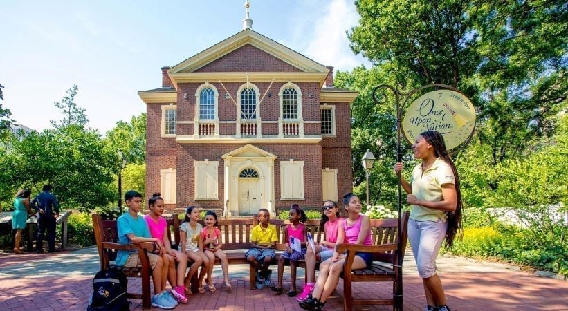 A woman tells children a story at one of the "Once Upon a Nation" history storytelling benches in Philadelphia.