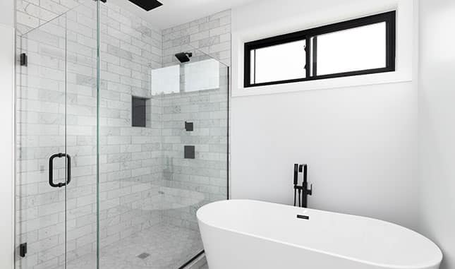 A simple, black-and-white walk-in shower with elegant fixtures