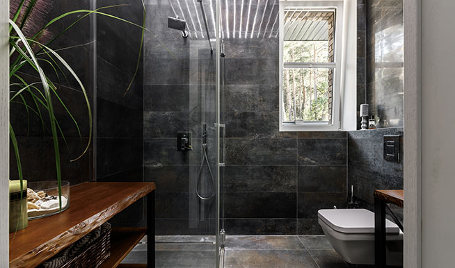 A bathroom that opts for dark greys and blacks in lieu of beiges and whites.