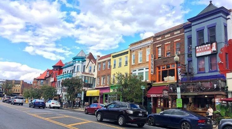 A colorful row of buildings line a street in Adams Morgan, a neighborhood in Washington, D.C.