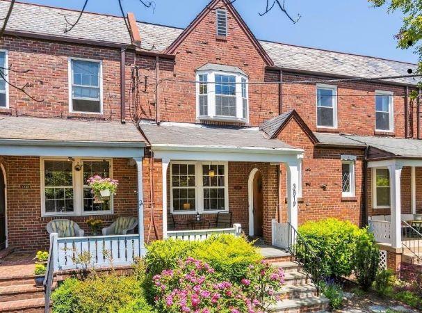 A large brick townhome in the Glover Park neighborhood of Washington, DC, featuring a covered porch and bay windows.