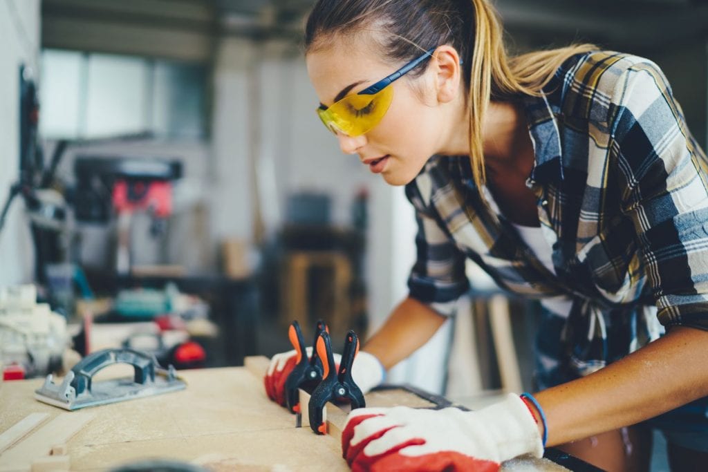 Woman wears PPE while working on project during social distancing
