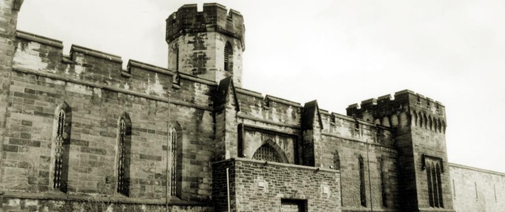 A historical black and white image of Eastern State Penitentiary in Philadelphia.