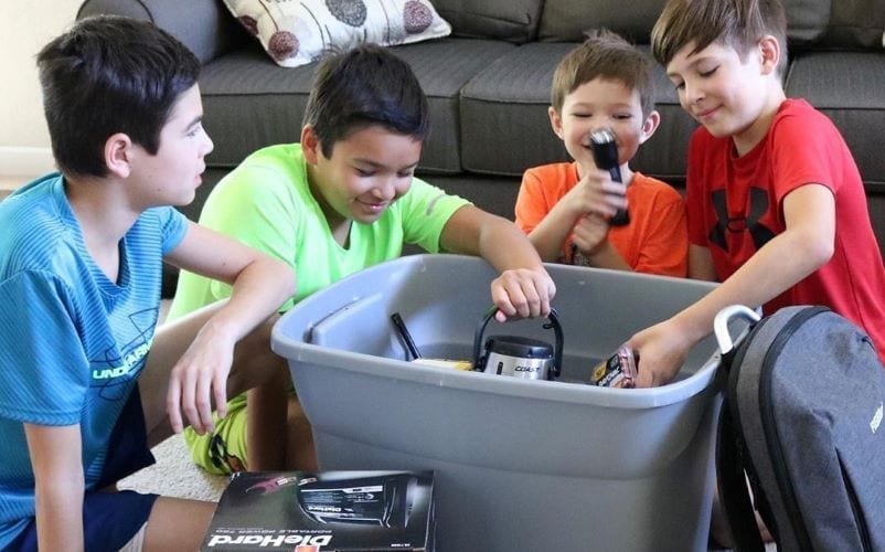 Four brothers assemble emergency kit in case of natural disaster.