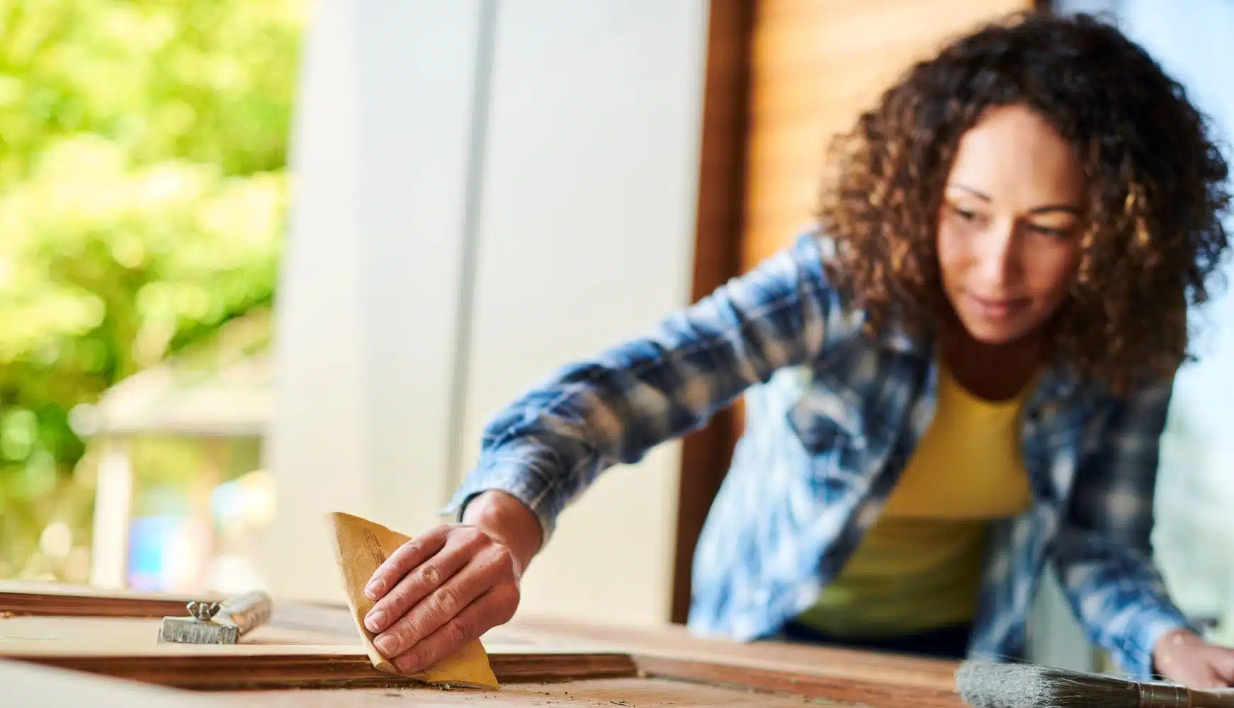 woman sanding DIY cabinet
