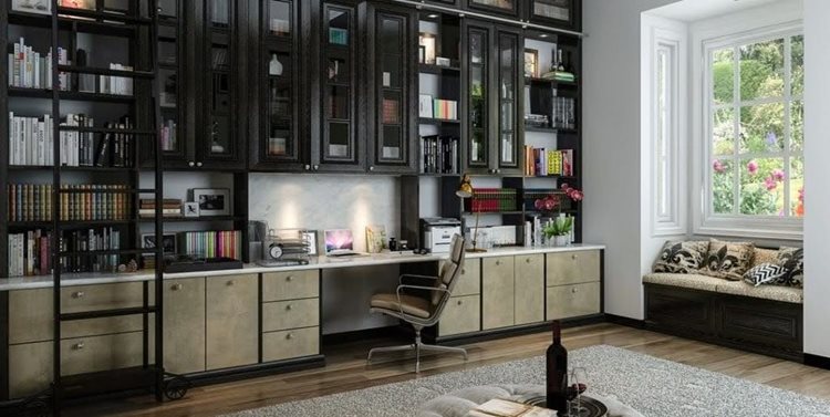 A stylish and versatile home office with a desk incorporated into the wall-to-wall counter space, with custom built-in bookshelves reaching toward the ceiling and a library ladder.