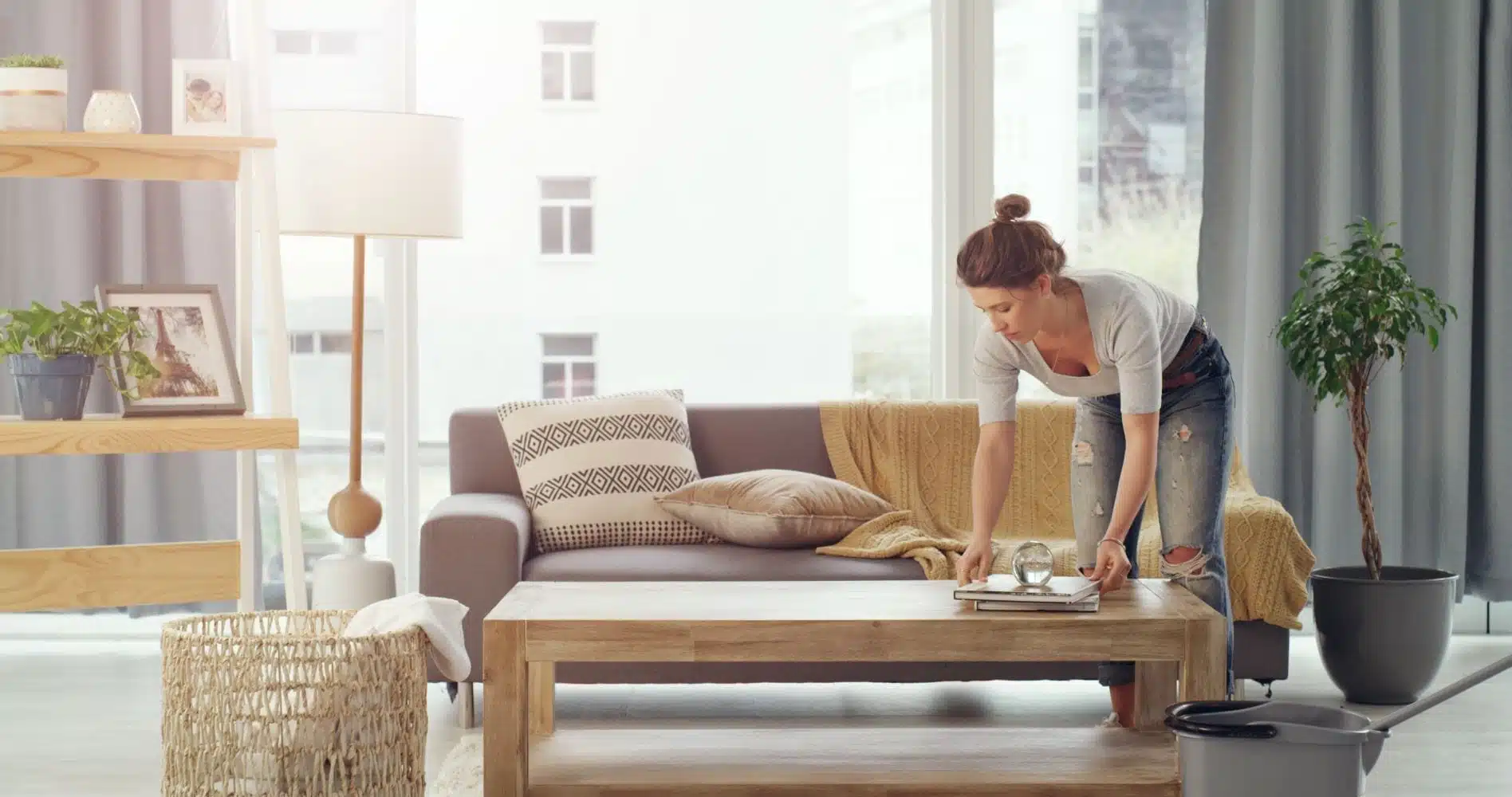 woman arranging books on a table in living room