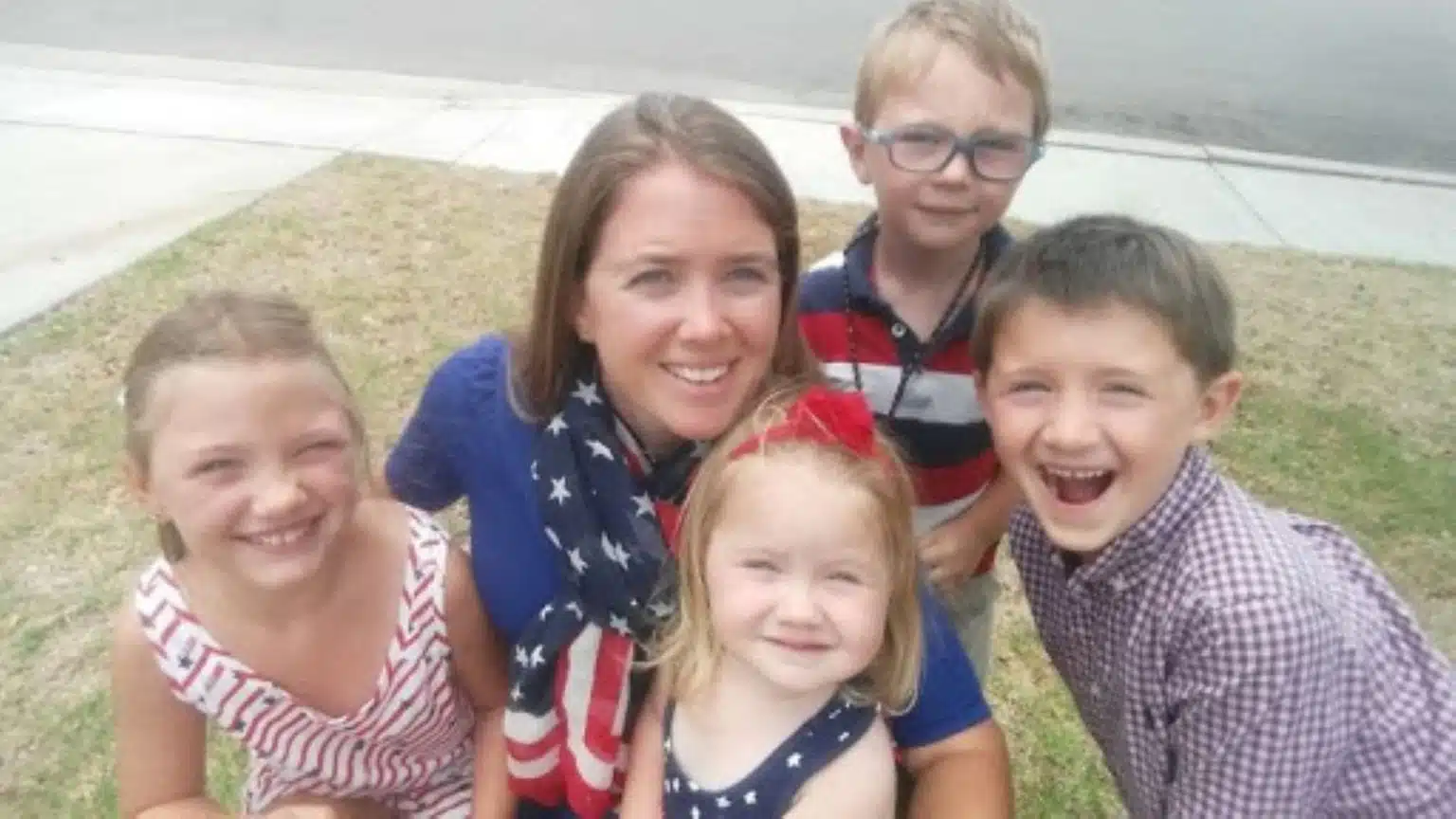 A photo of Lizann Lightfoot, a military mom with four or her five children, dressed in patriotic clothes and posing for a group selfie.