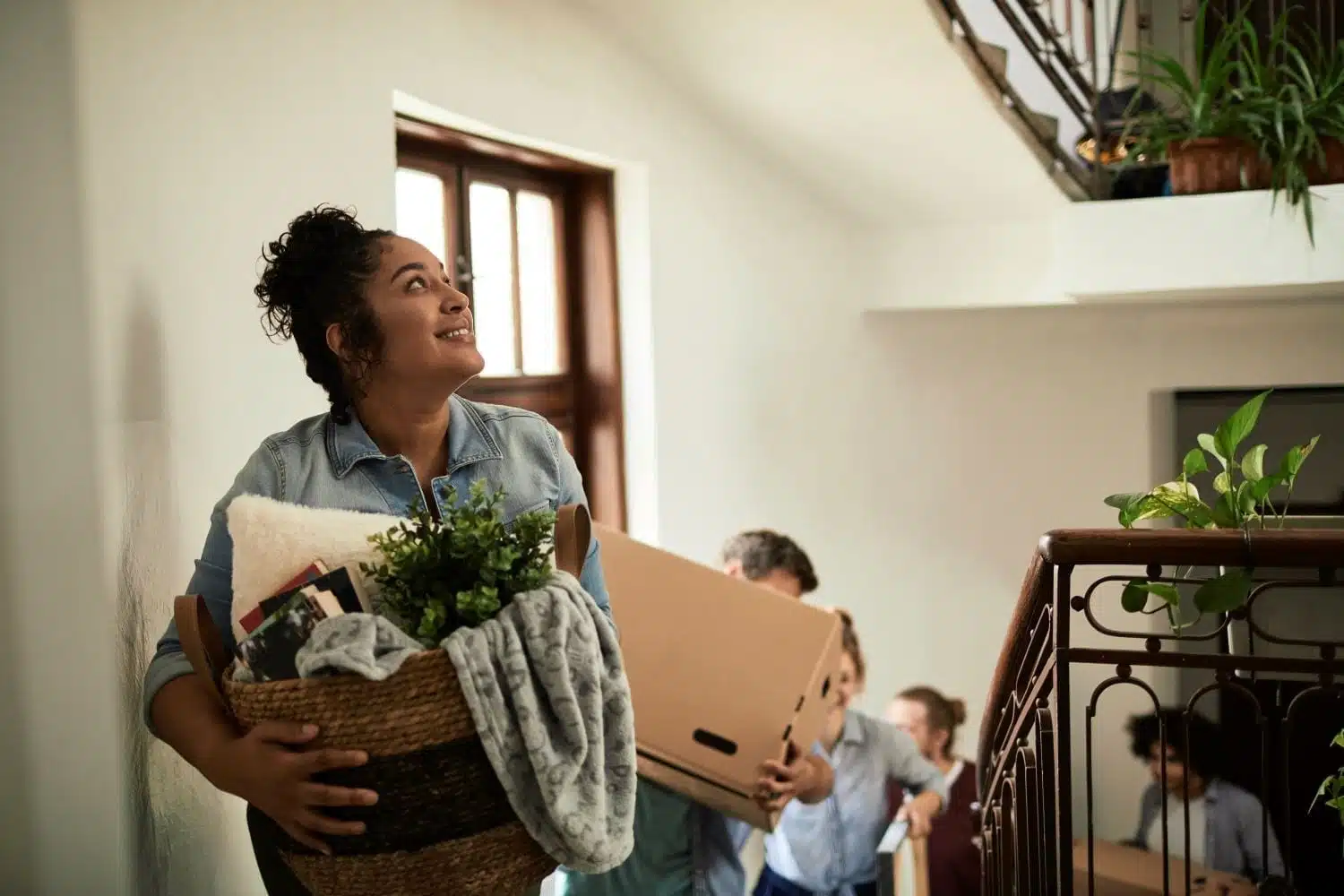 group of people carrying moving boxes upstairs