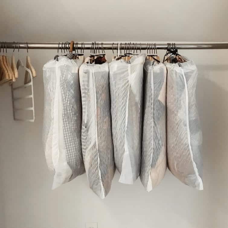 clothing grouped and packed in garbage bags on hangers