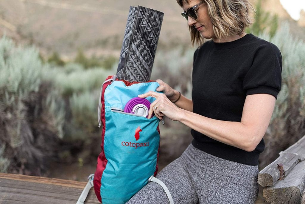 a woman packing a collapsible water bottle in her yoga bag