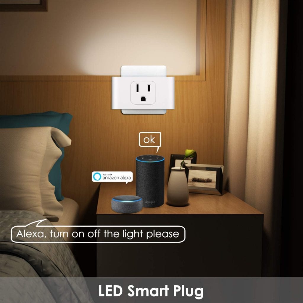 A smart plug beside a bed and several smart appliances on a nightstand