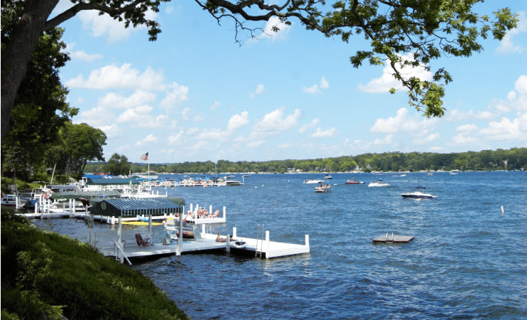 Residential docks and boats float on the blue waters of Geneva Lake in Lake Geneva, WI, on a beautiful summer day.