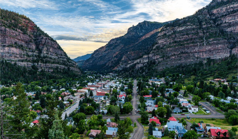 Aerial view of the small town of Ouray, Colorado, with mountains rising up all around the town.