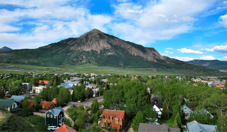 Aerial view of the town of Crested Butte, Colorado, in the summer with the Crested Butte mountain peak in the distance.