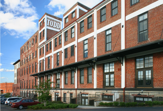 A five-story, brick apartment building in Richmond, Virginia, called “Todd Lofts.” There’s white detailing on the building and the word, “TODD” is painted on an exterior wall on the top floor. 