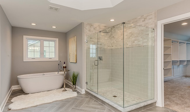 A large, neutral bathroom that uses interesting elements like a unique water spout and tiles to level it up.