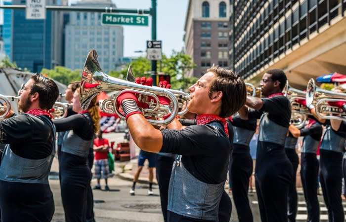 The brass section of a marching band pauses in the street as they play out a tune for onlookers in Philadelphia during an Independence Day Parade.