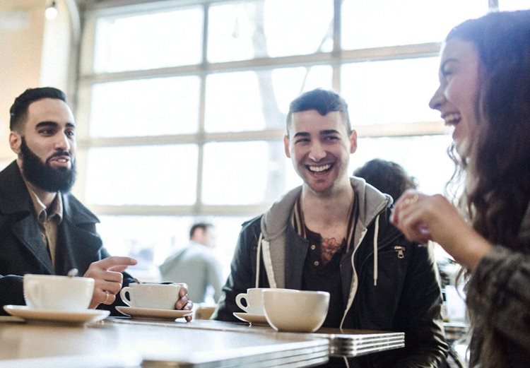Friends chatting and smiling over coffee i n a Seattle coffee shop