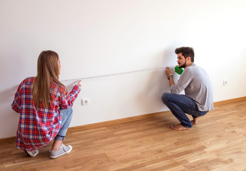 couple measuring a wall