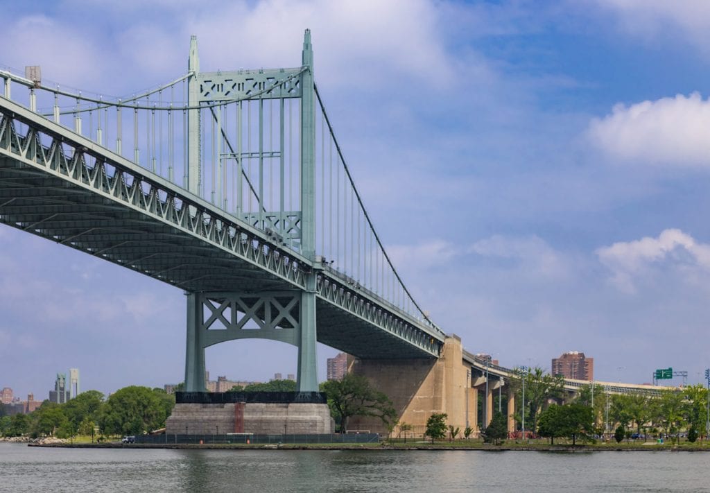 A train crossing a bridge over a body of water

Description automatically generated