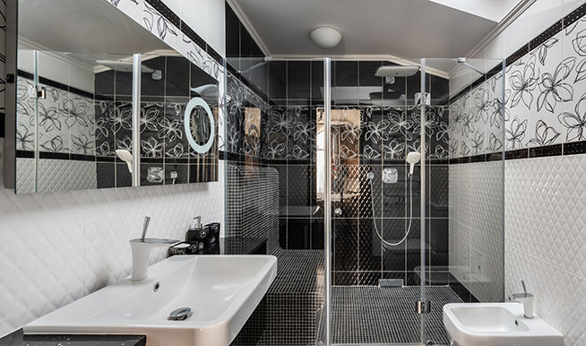 A black-and-white bathroom and shower with intricate designs, features, and accents that bring its boring color scheme to life