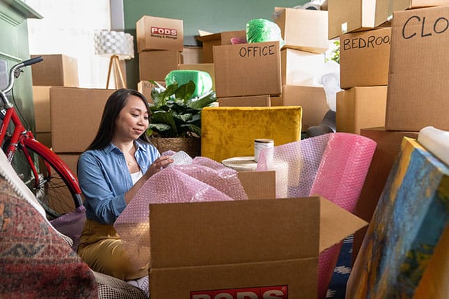 Someone making their move uses moving hacks to pack with purpose. Boxes are stacked high, ready to go.