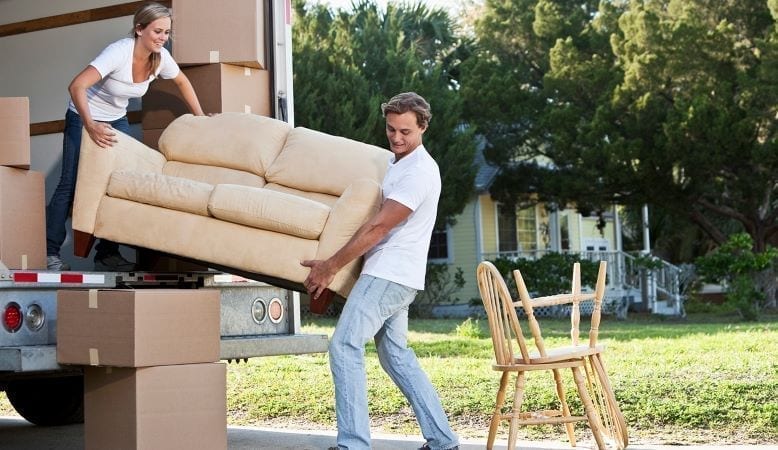 Couple unloads a sofa from a moving truck