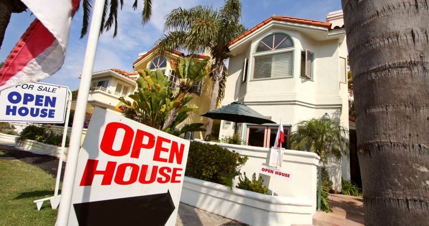 Home for sale with open house signs in front