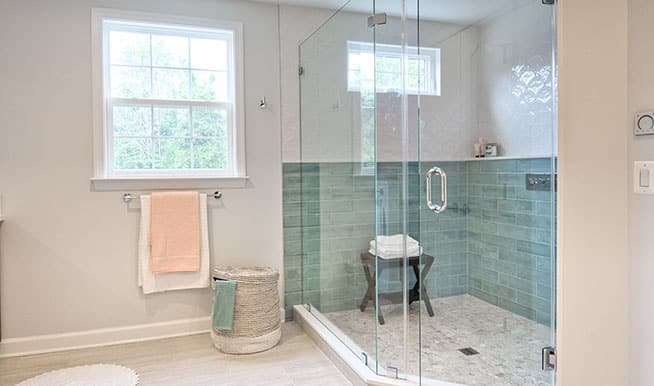 A walk-in shower with a pastel blue backdrop